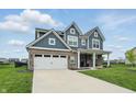 Beautiful blue two-story home featuring a spacious driveway, attached garage, and lush green lawn at 3650 Merchmont Rd, Bargersville, IN 46106