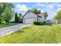 View of home with well-maintained lawn, an extended driveway, and convenient storage shed at 444 Austin Dr, Avon, IN 46123