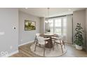 Well-lit dining area features a round table with modern chairs, complemented by natural light and hardwood flooring at 6038 Windsor Dr, McCordsville, IN 46055