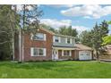 Two-story brick home with a well-manicured lawn, mature trees, and an attached garage at 6838 Johnson Rd, Indianapolis, IN 46220