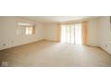 Bright, carpeted living room featuring large windows with curtains and a decorative wall mirror at 7317 Lions Head Dr # A, Indianapolis, IN 46260
