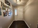 Inviting foyer with dark wood flooring and decorative wall art, leading into the home's living spaces at 7511 Eddie Ln, Camby, IN 46113