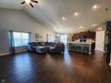 Open-concept living space with hardwood floors connecting the living room to the kitchen with an island and seating at 7511 Eddie Ln, Camby, IN 46113