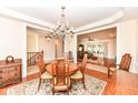 Open dining room with chandelier, hardwood floors, and views to other living areas at 10005 Southwind Dr, Indianapolis, IN 46256