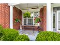 Charming front porch with hanging plants, a cozy bench, and decorative greenery at 10480 Stonegate Dr, Fishers, IN 46040