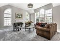Bright living room with large windows, a fireplace, and stylish modern furniture at 10480 Stonegate Dr, Fishers, IN 46040