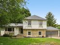 Charming two-story home featuring stone accents, neutral siding, lush lawn, and attached garage at 10778 Haverstick Rd, Carmel, IN 46033