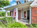Inviting front entrance featuring a decorative door, flag, and a well-manicured landscape at 1099 Saratoga Cir, Carmel, IN 46280