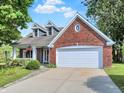 Charming brick home with well-maintained landscaping, dormer windows and an attached two car garage at 1099 Saratoga Cir, Carmel, IN 46280