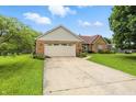 Attractive single-Gathering brick home boasting a large driveway and an attached two-car garage at 1106 Summer Way Ct, Shelbyville, IN 46176