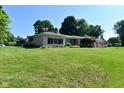 Well-maintained home with lush front lawn, mature trees, and attached two-car garage at 136 W Loretta Dr, Indianapolis, IN 46217