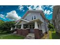 Inviting two-story home with a classic front porch and lush greenery, offering a blend of comfort and style at 1427 N Lasalle St # 1427, Indianapolis, IN 46201