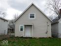 Rear exterior of a house with neutral siding and a small porch, surrounded by a yard at 1553 W New York St, Indianapolis, IN 46222