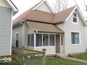 Street view of a cozy home featuring neutral siding and a covered front porch at 1553 W New York St, Indianapolis, IN 46222