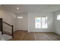 Bright, unfinished living area with a staircase and a large window allowing natural light at 1817 Real St, Indianapolis, IN 46240