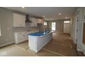 Stylish kitchen featuring a spacious island with sink, white cabinetry, and a modern range hood at 1821 Real St, Indianapolis, IN 46240