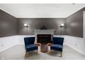 Cozy living room with fireplace, wall sconces, and two chairs for conversations and relaxation at 2508 W Sun Valley Pkwy, Muncie, IN 47303