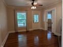 Empty living room with hardwood floors, windows, sliding doors, and neutral colors at 414 E Main St, Plainfield, IN 46168