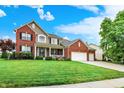 Charming two-story brick home with a well-manicured lawn, beautiful landscaping, and a three car attached garage at 564 Gainesway N Dr, Greenwood, IN 46142