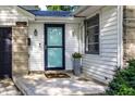 Close up of the front door and porch of a well-maintained home, with blue accents and a decorative flower pot at 5736 Primrose Ave, Indianapolis, IN 46220