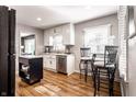 Bright kitchen featuring an island, stainless steel appliances, white cabinets and wood flooring at 5736 Primrose Ave, Indianapolis, IN 46220