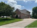 Beautiful brick home showcasing a three-car garage and spacious driveway at 5775 Coopers Hawk Dr, Carmel, IN 46033