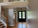 Bright foyer with hardwood floors, a staircase, and a view of the front door at 5775 Coopers Hawk Dr, Carmel, IN 46033