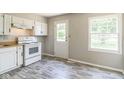 Functional kitchen with white cabinetry, an electric stove, and modern flooring at 609 Willow Dr, Shelbyville, IN 46176