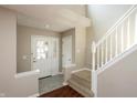 Bright foyer featuring a staircase, high ceilings, and a view of the front door with glass panes at 6465 Robinsrock Dr, Indianapolis, IN 46268