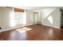 Open living room with hardwood floors, natural light, and a view of the entrance and staircase at 6465 Robinsrock Dr, Indianapolis, IN 46268