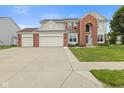 Charming two-story home with a well-manicured lawn, a three-car garage and a red brick facade at 7350 Gold King Way, Indianapolis, IN 46259