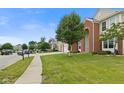 Charming two-story home with a well-manicured lawn, a three-car garage and a red brick facade at 7350 Gold King Way, Indianapolis, IN 46259