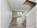 A foyer with a staircase and view to the living room and wood-look vinyl plank flooring at 7572 Wymm Ln, Ingalls, IN 46048