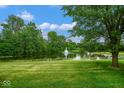 Tranquil backyard with a scenic pond and fountain surrounded by lush greenery at 8047 Red Barn Cir, Indianapolis, IN 46239