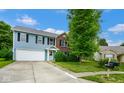 Lovely two-story home with a mix of blue siding and brick, complemented by a spacious driveway at 8047 Red Barn Cir, Indianapolis, IN 46239
