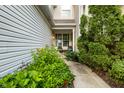 Inviting covered porch with seating area and lush greenery, creating a private entrance at 9525 Longwell Dr, Indianapolis, IN 46240