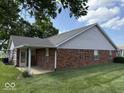 A well-maintained brick home with a cozy, covered patio area and a lush, green lawn, perfect for outdoor enjoyment at 989 Plaza Dr, Martinsville, IN 46151