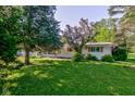Single story home boasting well-maintained landscaping and mature trees in a charming neighborhood at 10065 E 25Th St, Indianapolis, IN 46229