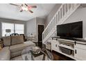 Cozy living room with a gray sofa, glass coffee table, and a mounted TV for entertainment at 1106 Barbara Dr, Greenwood, IN 46143