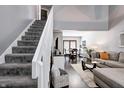 Open-concept living room featuring a staircase, gray walls, and a comfortable sectional sofa at 1106 Barbara Dr, Greenwood, IN 46143