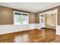 Bright living room featuring hardwood floors, large window, and elegant trim work, adjacent to the entryway at 11250 N 600 W, Fountaintown, IN 46130