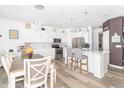 Open-concept kitchen with modern lighting, stainless steel appliances, and a breakfast bar island at 1156 Brockton Ct, Greenfield, IN 46140