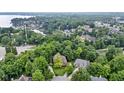 An aerial view showcases the house nestled among lush trees and a nearby lake at 12214 Ridgeside Rd, Indianapolis, IN 46256