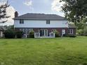 The spacious backyard features a lush lawn, patio and brick exterior with white siding at 13221 Griffin Run, Carmel, IN 46033