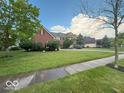 Charming two-story brick home with a lush green lawn and mature trees at 13221 Griffin Run, Carmel, IN 46033
