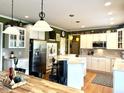 Bright kitchen with white cabinetry, stainless steel appliances, and a breakfast bar with pendant lighting at 13221 Griffin Run, Carmel, IN 46033
