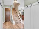 Bright foyer with stairs leading up, coat closet and light wood-look vinyl floors at 1357 Brownswood Dr, Brownsburg, IN 46112