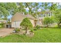 Inviting tan two-story home featuring well-maintained landscaping and an attached two-car garage at 1357 Brownswood Dr, Brownsburg, IN 46112