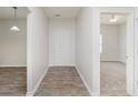 Bright entryway with wood-look flooring, white walls, and a glimpse of a carpeted bedroom at 15388 Dry Creek Rd, Noblesville, IN 46060