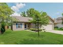 Inviting home exterior with green lawn, mature tree, and a two-car attached garage at 15388 Dry Creek Rd, Noblesville, IN 46060